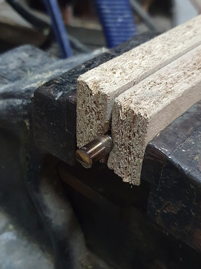 Eixo cortado no meio de duas madeiras